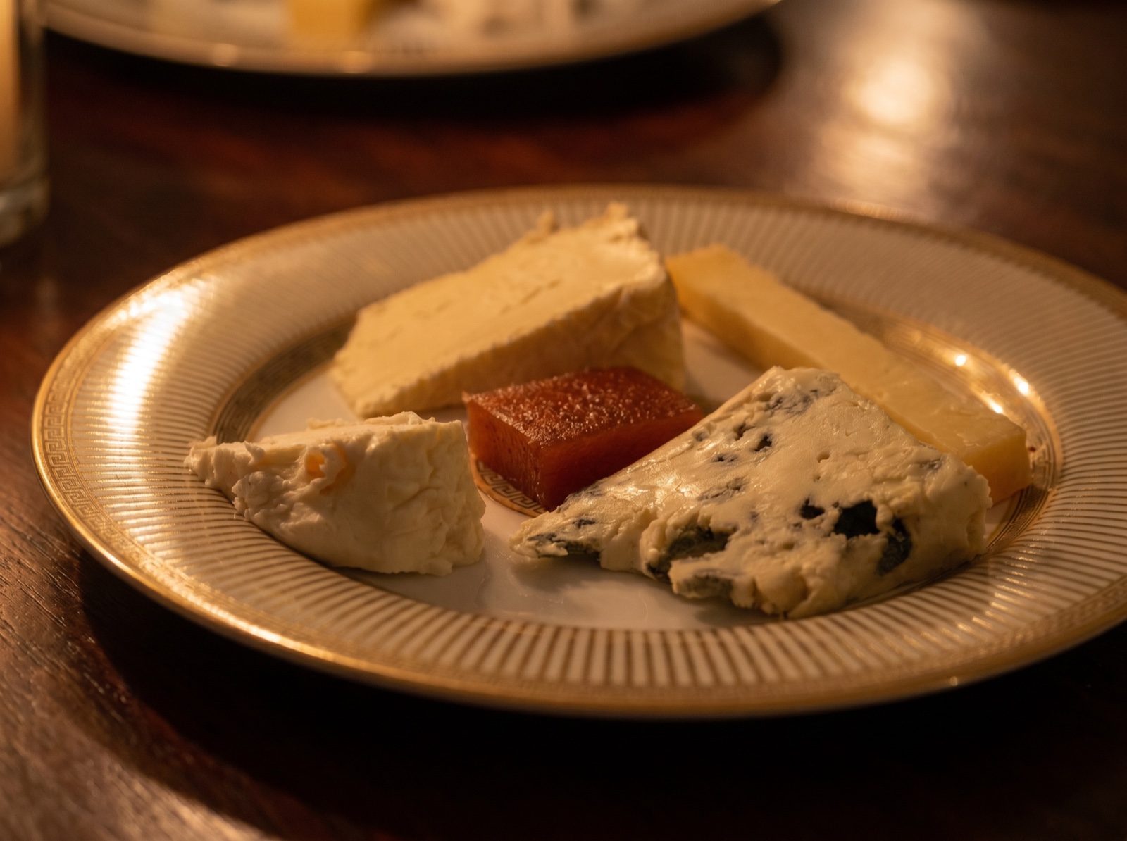 Plateau de fromages affinés dressé sur une assiette au liseré doré
