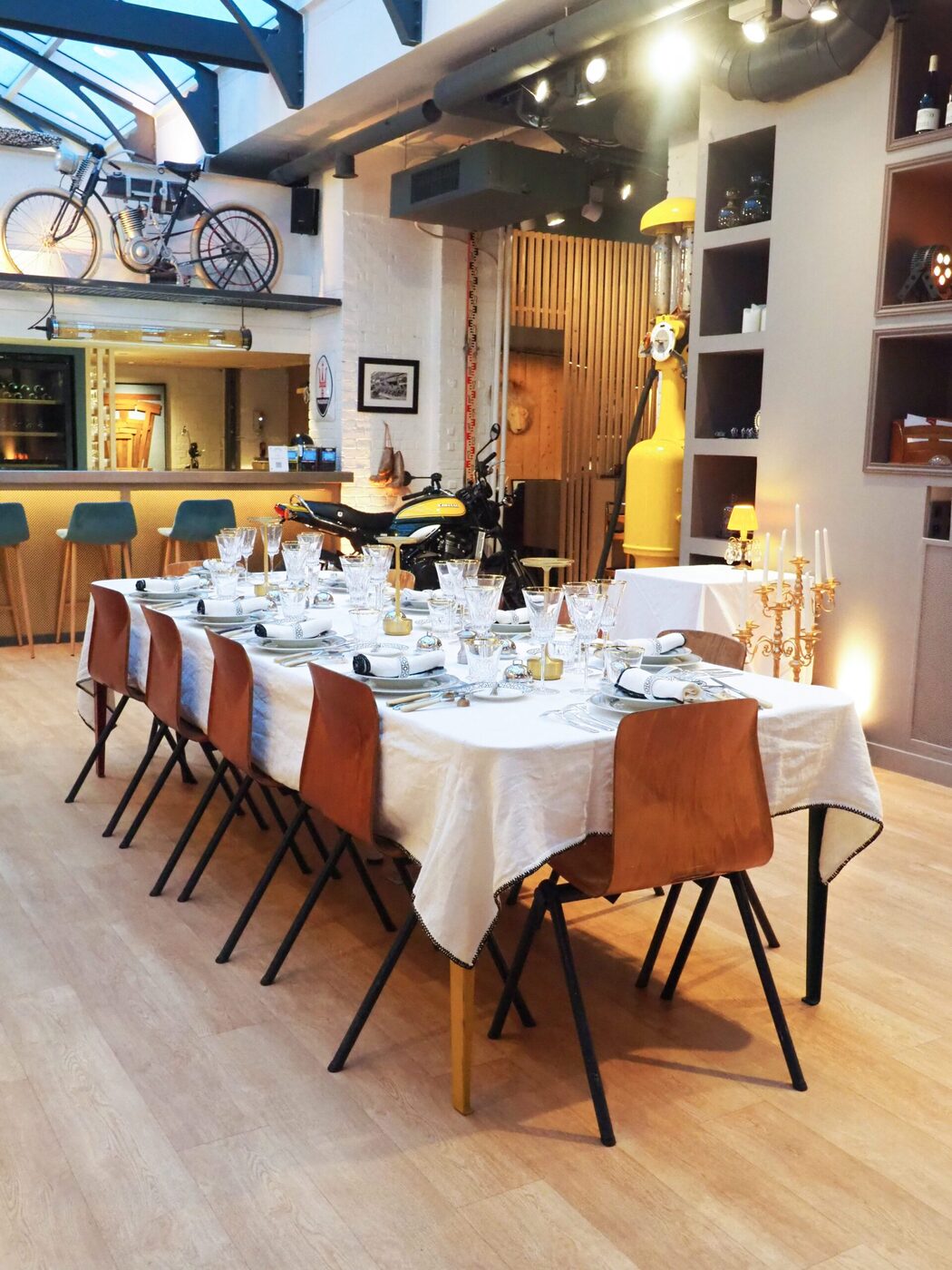 Grande table dressée pour un comité de direction, nappage blanc, candélabres, verres de cristal, ambiance feutrée