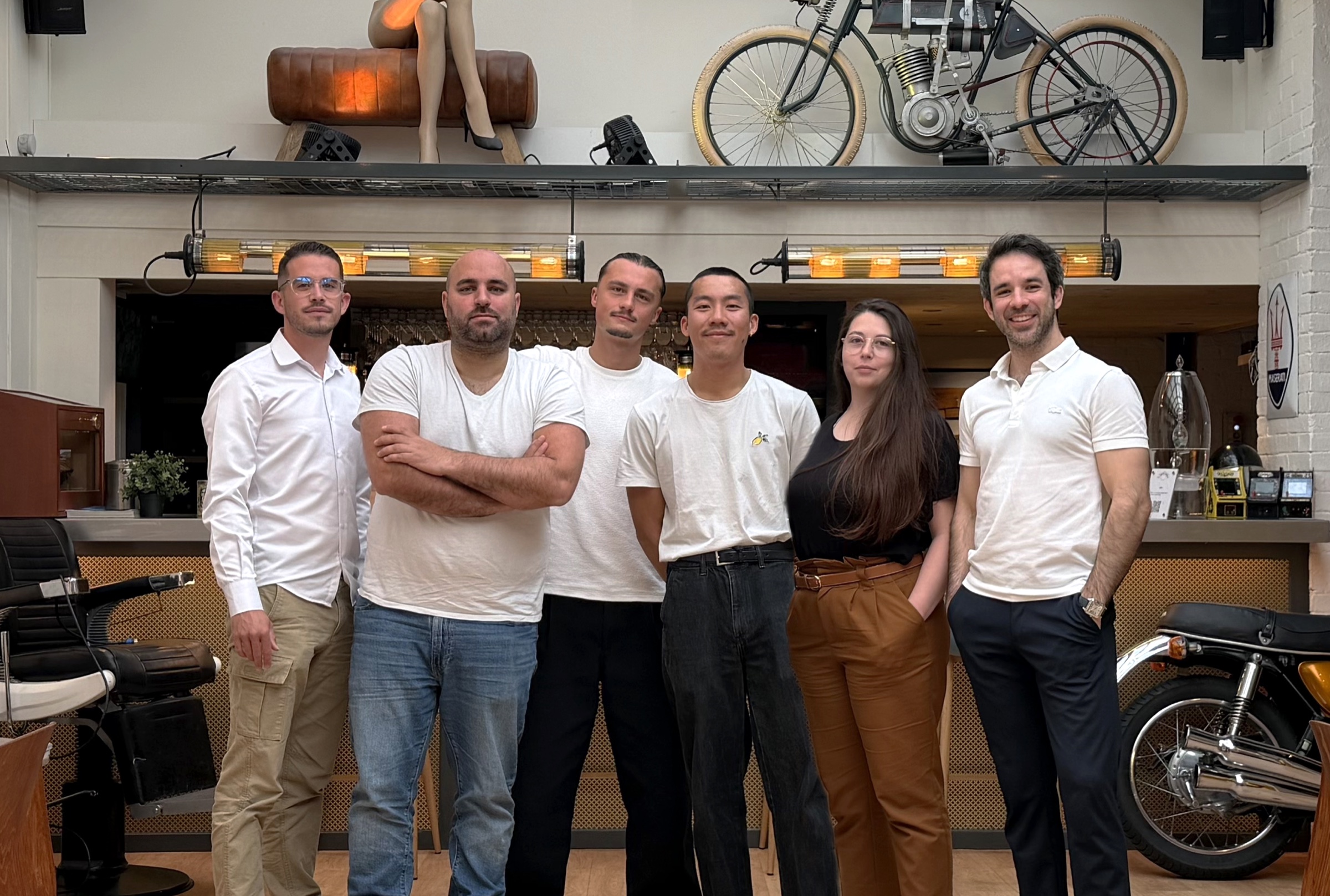L'équipe permanente de La Fabrique Générale, Julien, Olivier et leurs collaborateurs sous la verrière, devant le bar et les motos d'époque